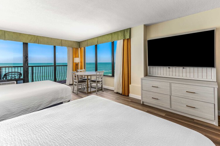 Two queen beds beside a private balcony