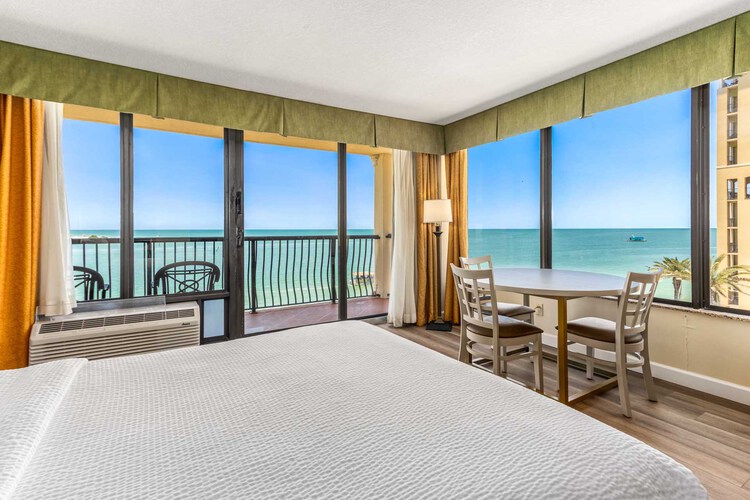King bed beside a private balcony with Gulf view